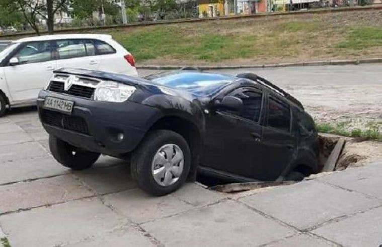 В Киеве припаркованный внедорожник ушел под землю 1